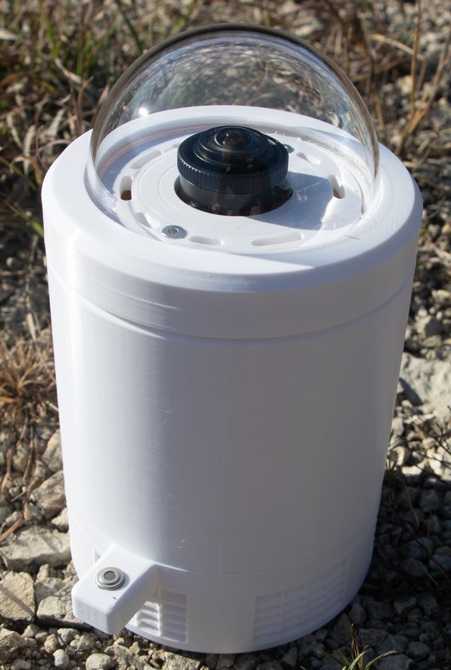 An AllSkyLabs Horizon all-sky camera with a clear dome, set outdoors on gravel